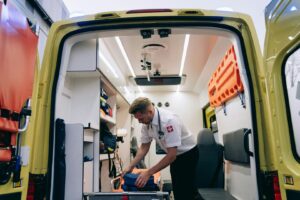 Sjukvårdare organiserar utrustning i en välutrustad ambulansbil.