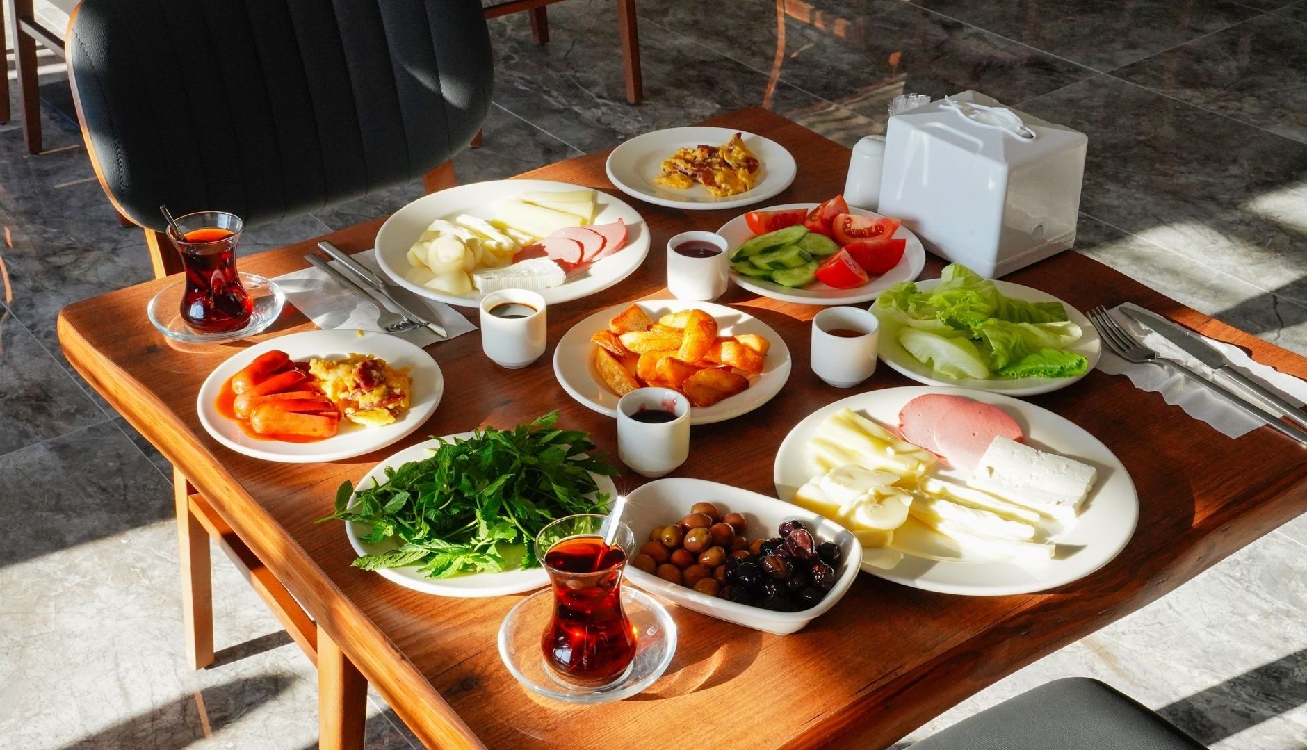 Omsorgsfullt upplagd frukost med te, bröd, ost, grönsaker och frukt