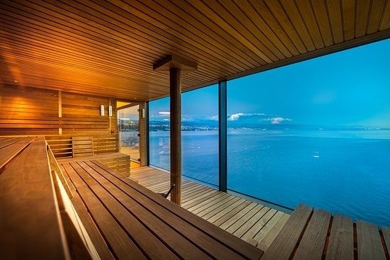 Träklädd bastu med stora fönster och utsikt över havet